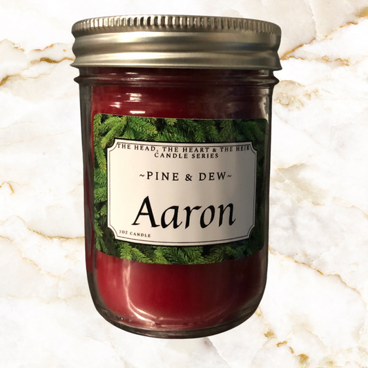 Red candle in 250 ml mason jar - Label says Aaron with Pine & Dew label